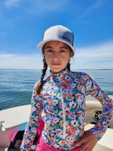 Fille en casquette sur un bateau sur la mer